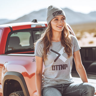 OTTNP model sitting in the back of a Toyota Tacoma pickup truck wearing our light grey black and white logo t-shirt. ottnp.com